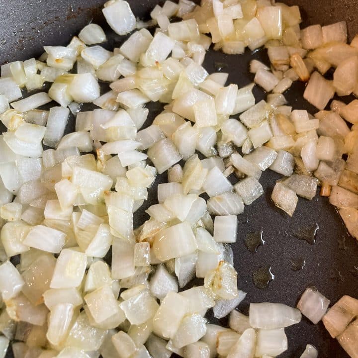 Sautéed onions in a black frying pan