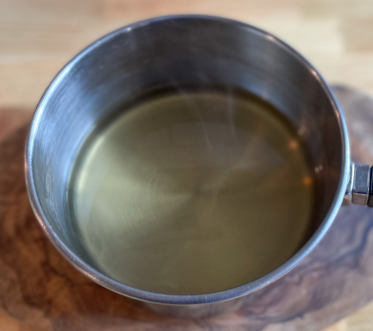 Pickling brine is warmed in a stainless steel pot.