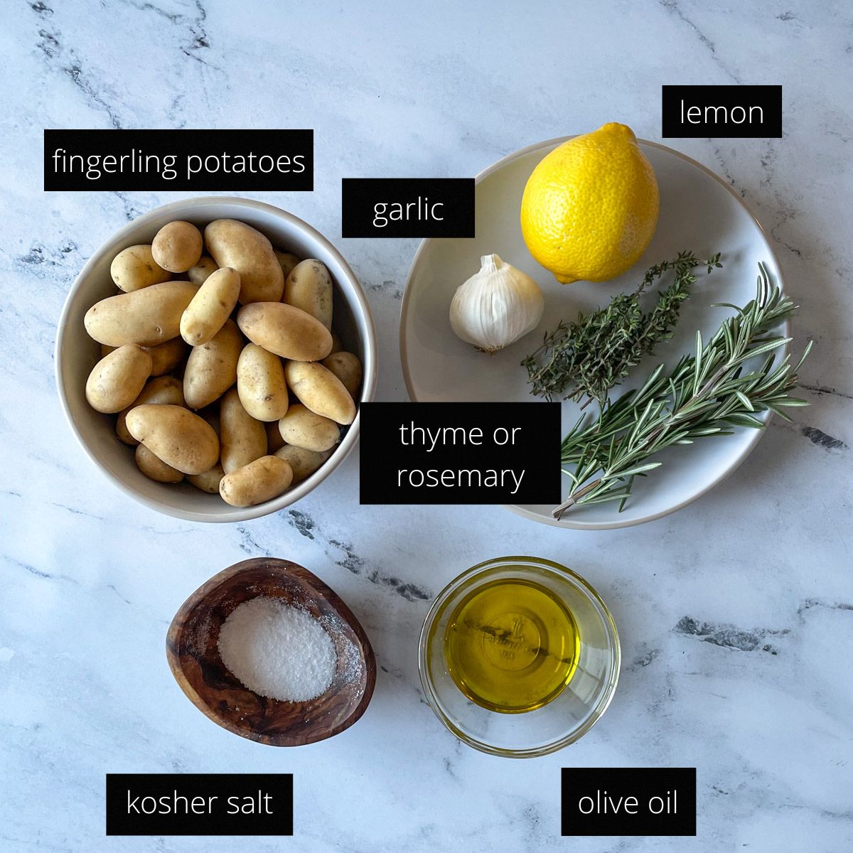 A labeled photo with the ingredients for Air Fryer Fingerling Potatoes, including potatoes, lemon, garlic, thyme, rosemary, kosher salt, and olive oil.