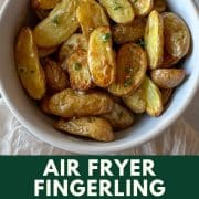 Air Fryer roasted fingerling potatoes in a white bowl with text displaying the title of the recipe and the URL for Two Cloves Kitchen.