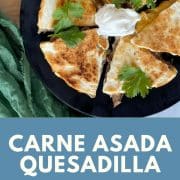 Carne asada quesadilla cut into six pieces and topped with cilantro and cream on a black plate. The bottom half of the image has a blue background with the words Carne Asada Quesadilla and the URL for Two Cloves Kitchen.