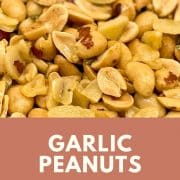 Image shows close-up shot of garlic peanuts with chopped rosemary.
