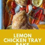 Two crispy skinned chicken thighs sit on a sheet tray surrounded by roasted baby sweet peppers, sliced lemon, quartered shallots, garlic, thyme, and cherry tomatoes. Text with recipe name and Two Cloves Kitchen URL is shown on a yellow background.