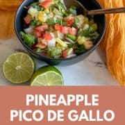Pineapple pico de gallo in a black bowl with title of recipe and URL for Two Cloves Kitchen.