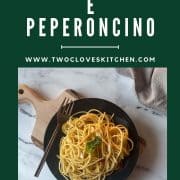 Pinterest Pin showing a black plate of twirled Aglio Olio e Peperoncino garnished with basil on a white marble counter with title of recipe and URL www.twocloveskitchen.com.