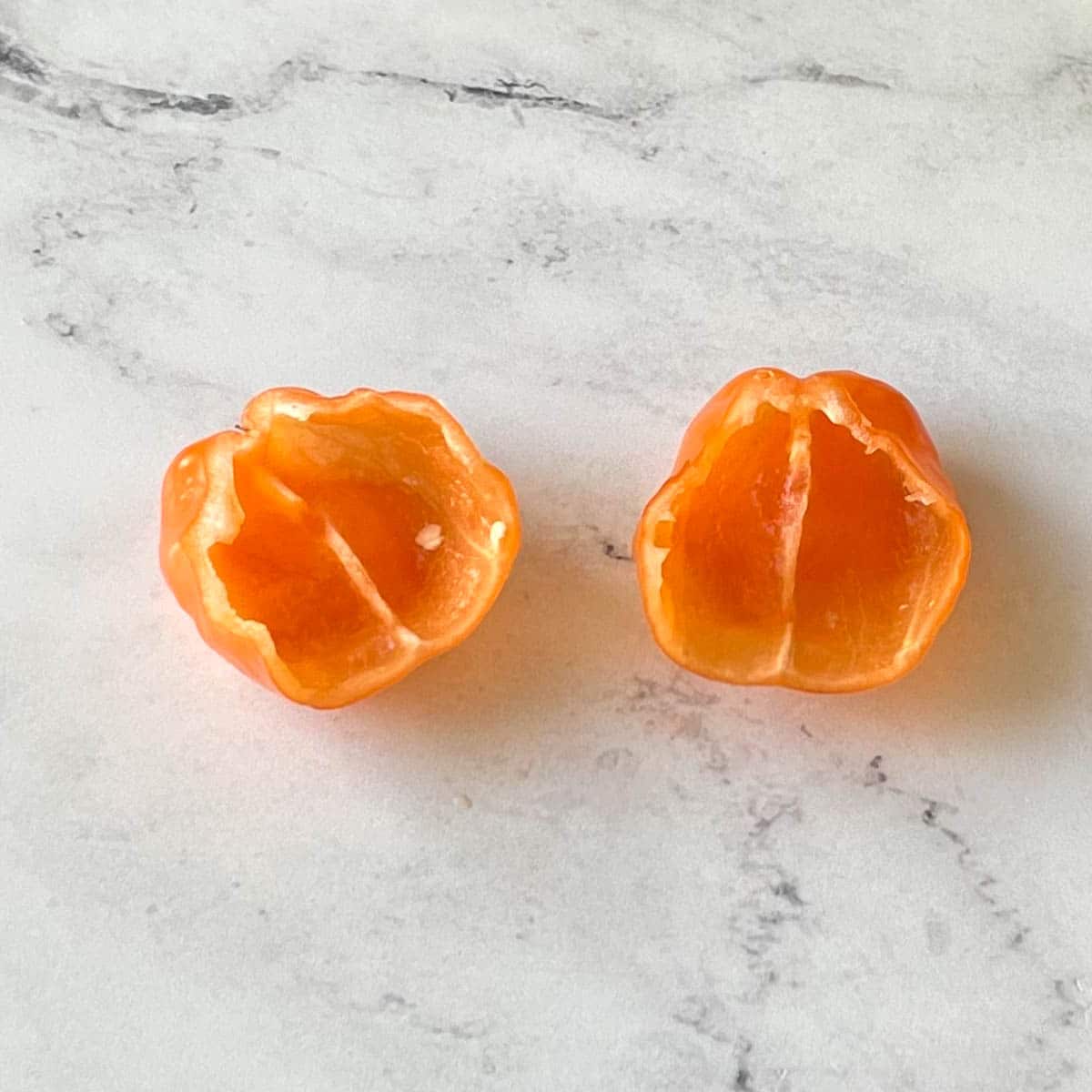 A deseeded and deveined habanero pepper sits on a white marble counter.