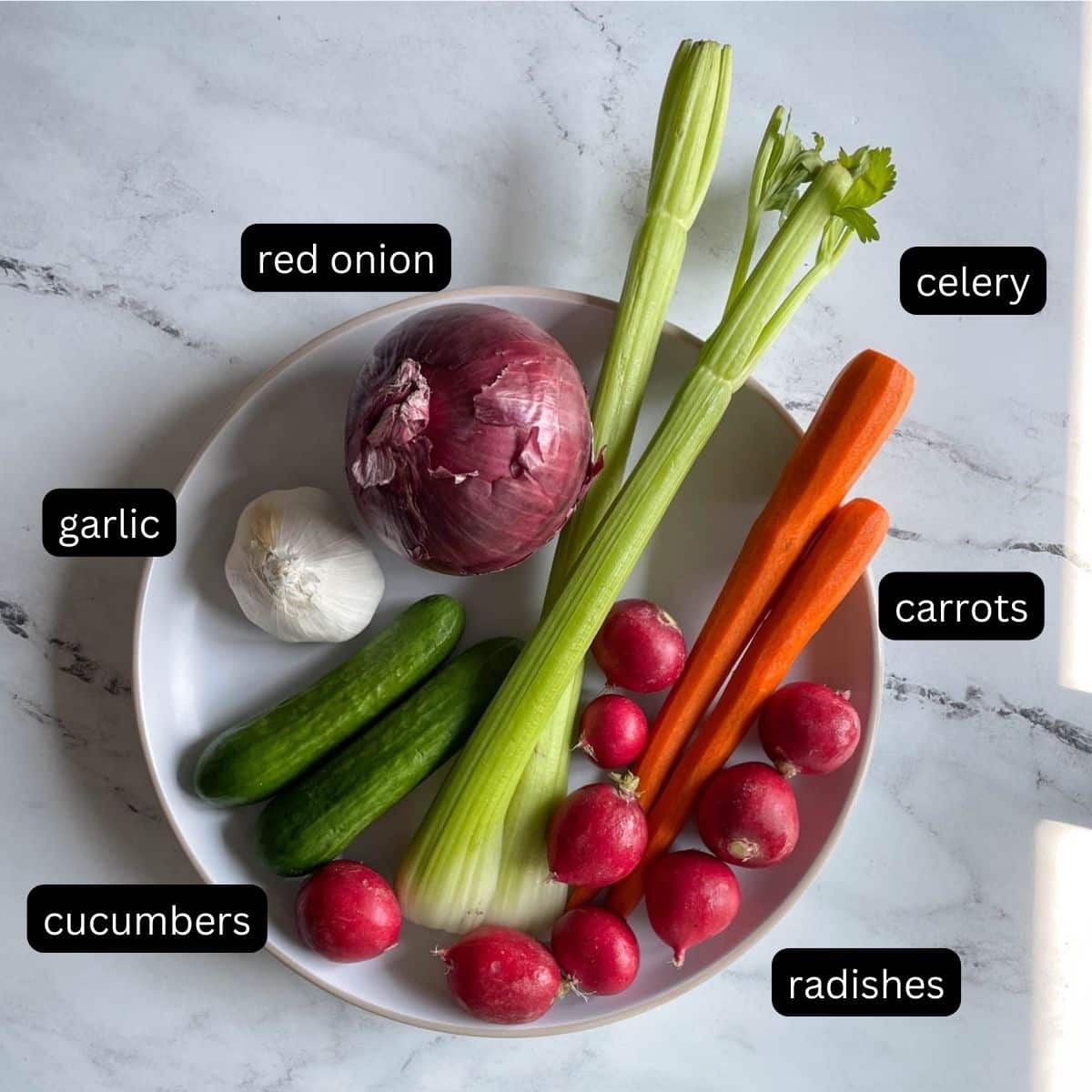 Labeled mixed vegetables are shown on a white plate.