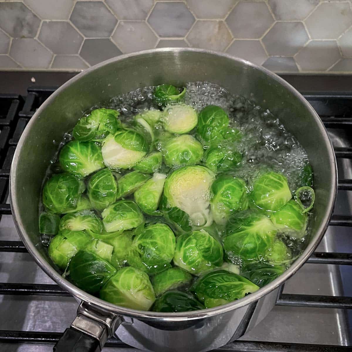 Halved brussels sprouts are blanched in boiling water.