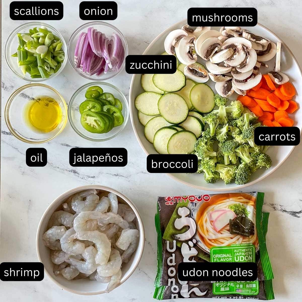 The labeled ingredients for shrimp yaki udon are shown on a white marble counter.