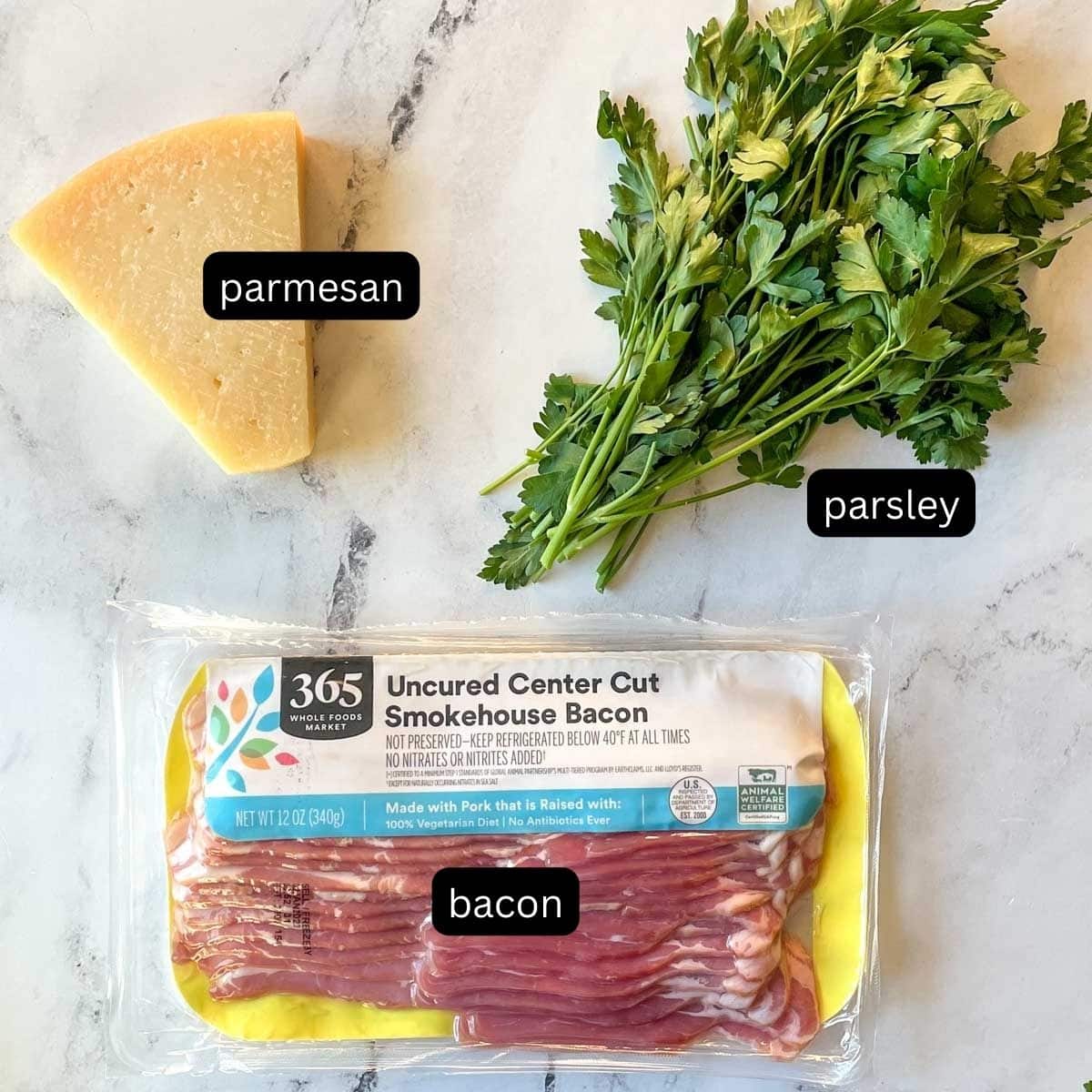 Parmesan, fresh parsley, and bacon are shown on a white marble counter.