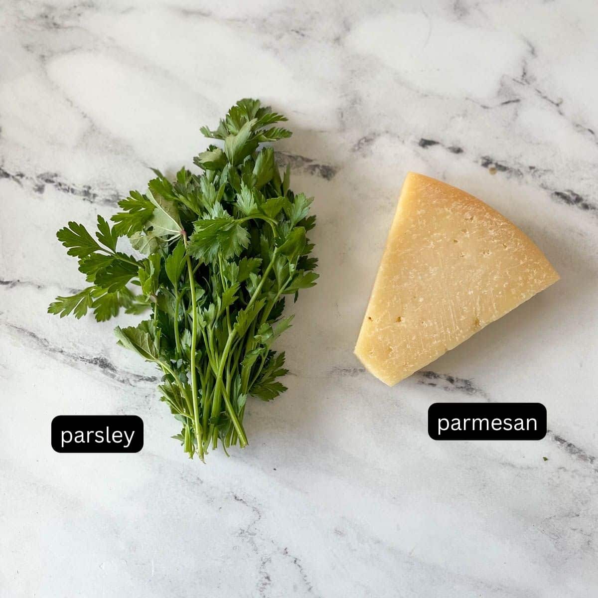 Labeled parsley and parmesan sit on a white marble counter.