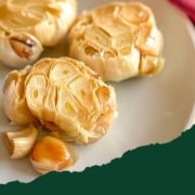 Three heads of roasted garlic are shown with the words Roasted Garlic and the URL www.twocloveskitchen.com.