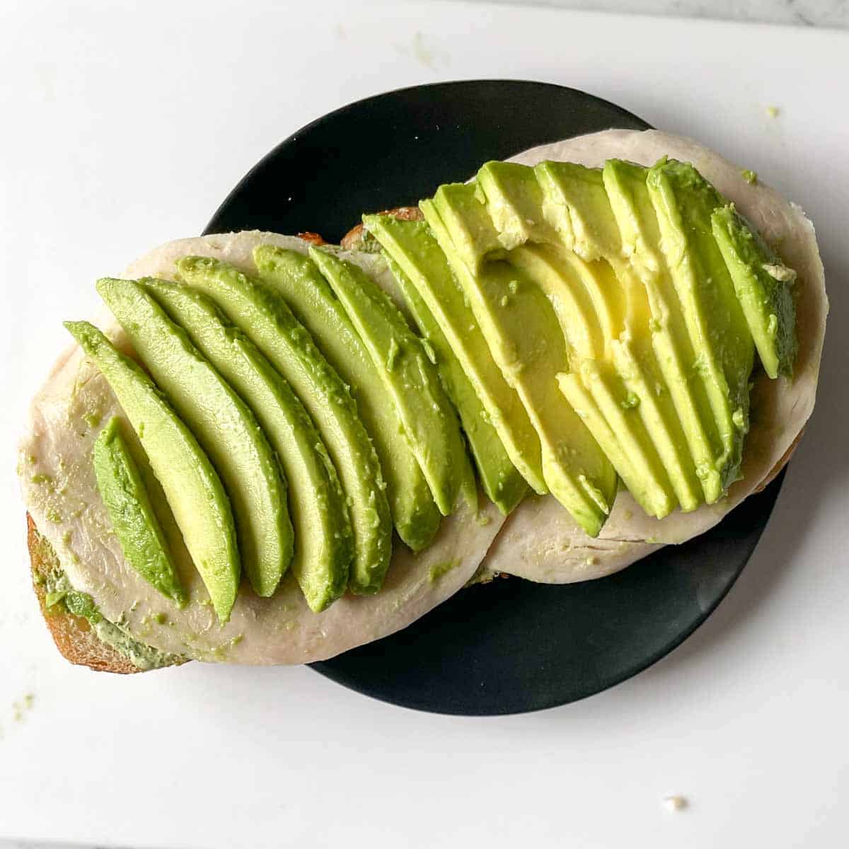 Avocado is added to the sandwich.