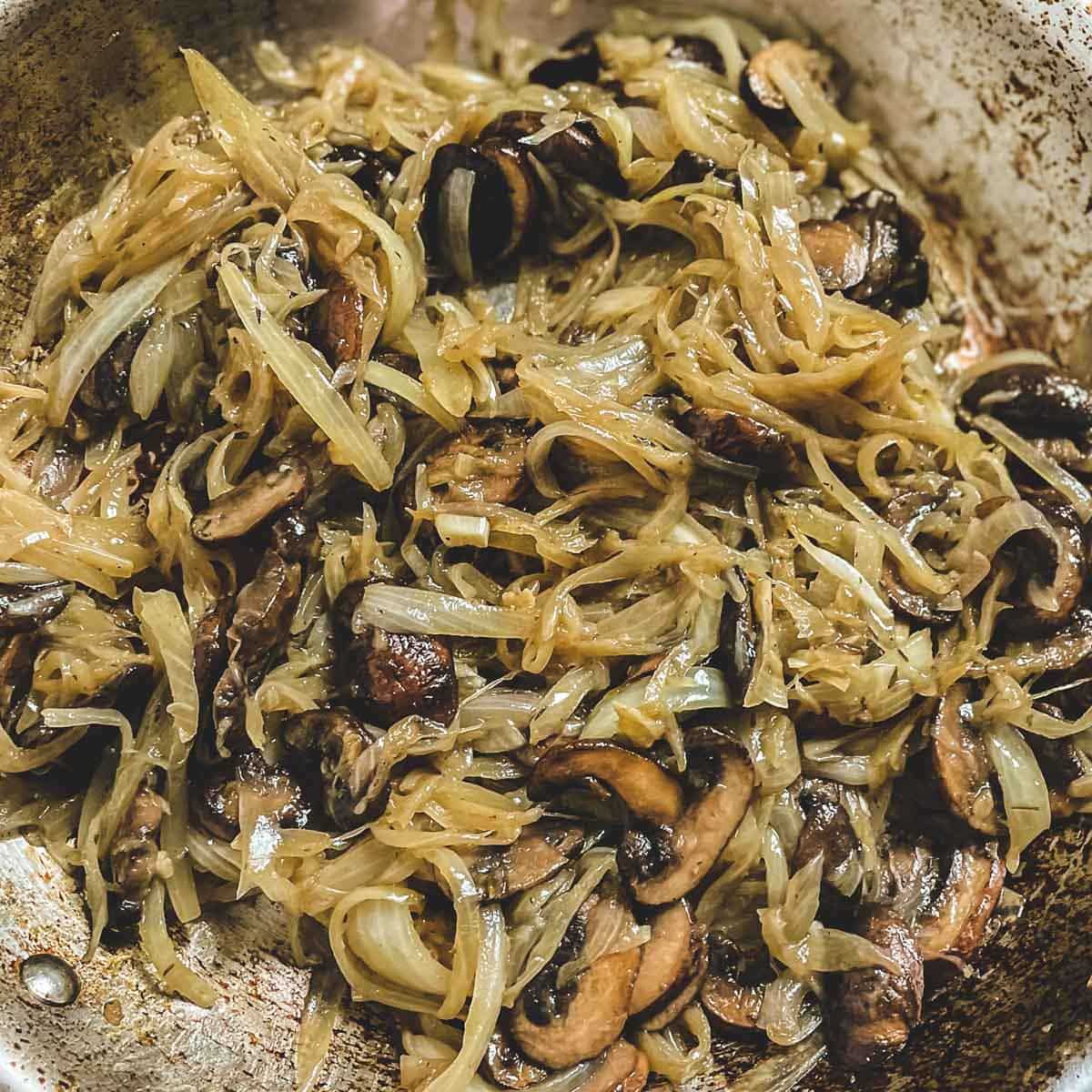 The caramelized onions and mushrooms are quite soft and are a light golden brown color.