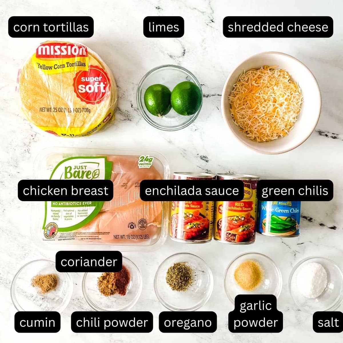 The labeled ingredients for chicken slow cooker enchiladas are shown on a white marble counter.