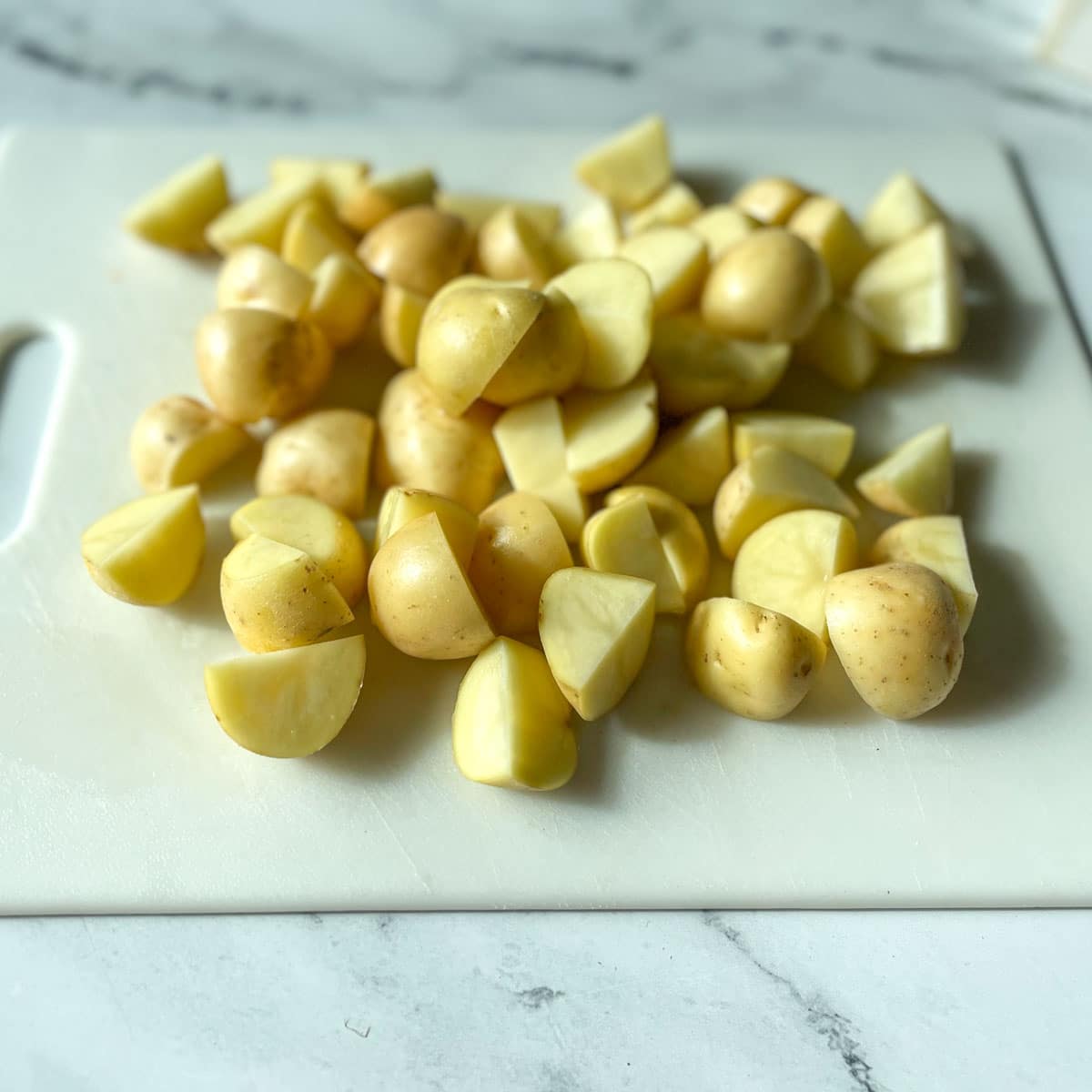 Baby yellow potatoes are cut into quarters.