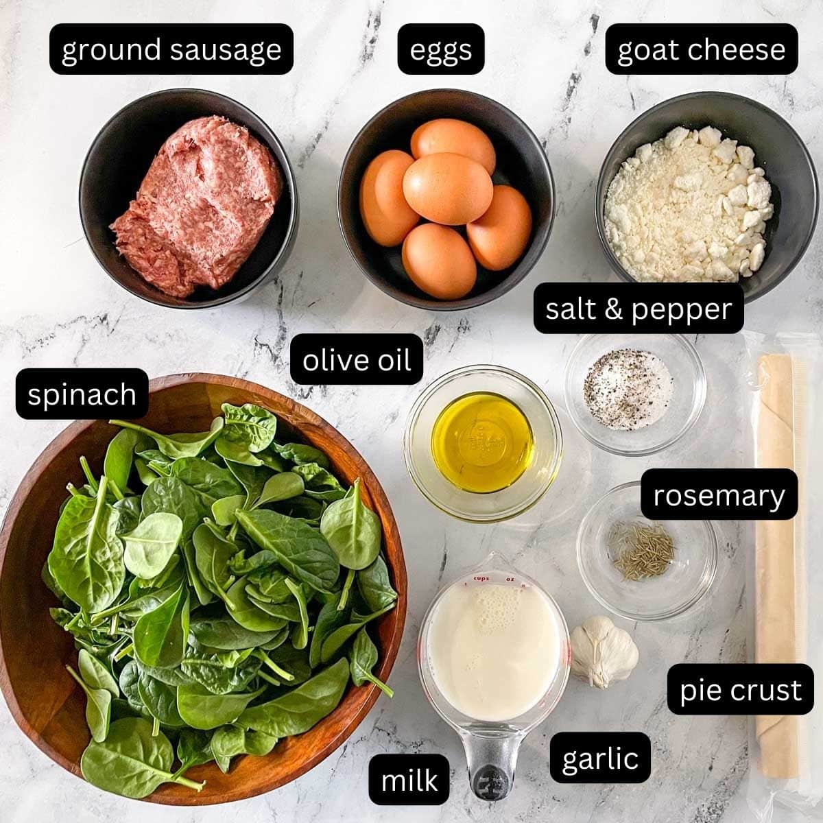 The labeled ingredients for sausage spinach quiche is shown on a white marble counter.