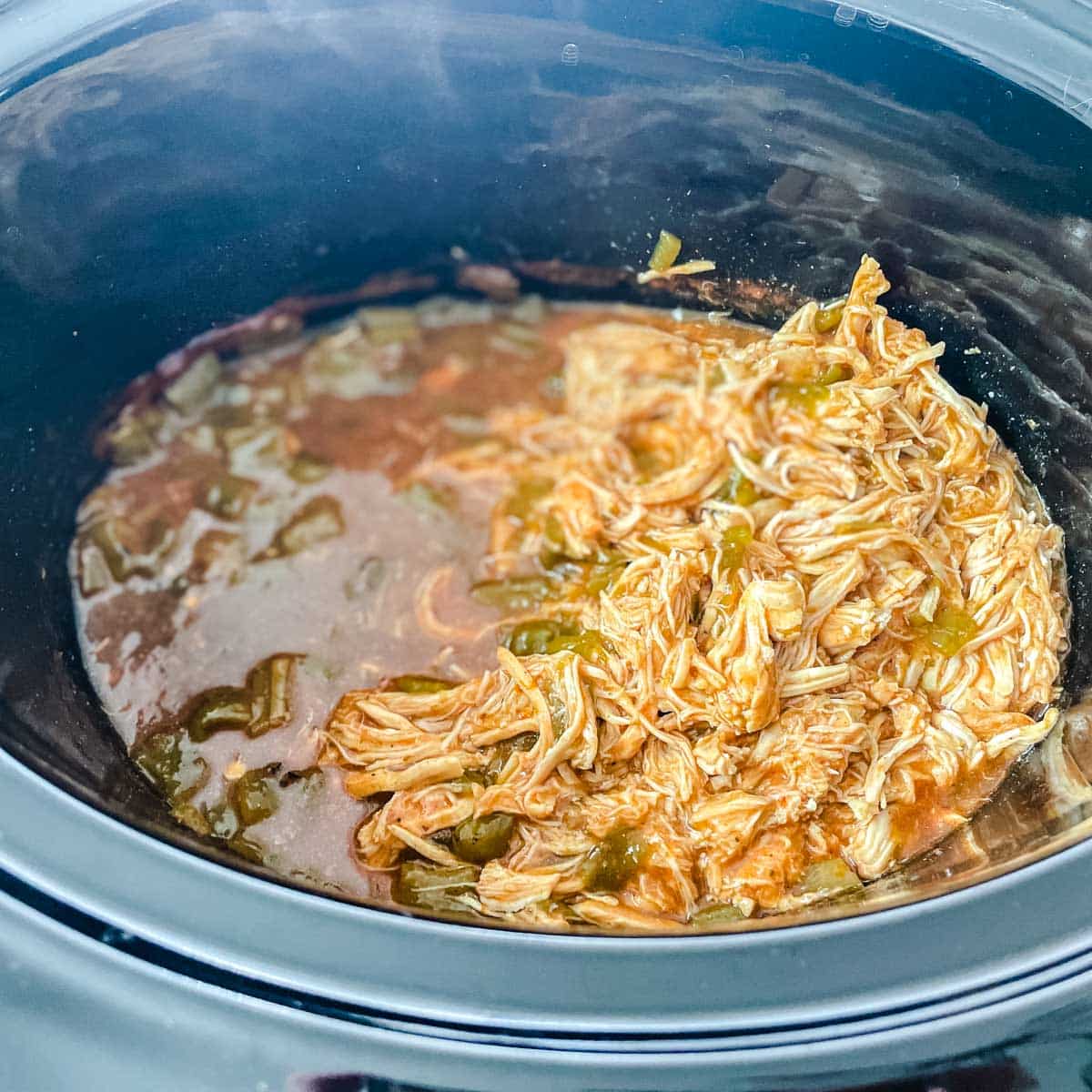 Shredded chicken is added back to the crockpot.