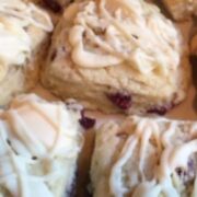 Raspberry white chocolate scones are drizzled with frosting.