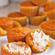 Pumpkin muffins are spread with butter.