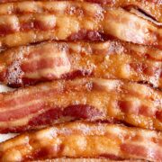 A closeup of sizzling bacon is shown.