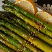Lemon asparagus is shown on a white platter.