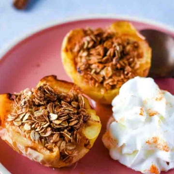 Air fryer baked apples are shown on a pink plate with whipped cream.