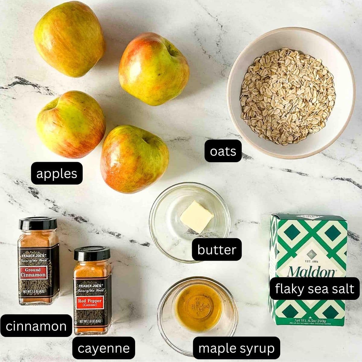 The ingredients for air fryer baked apples sit on a white marble counter.