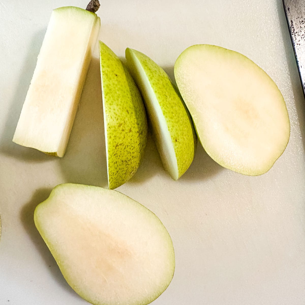 Sliced pears on a white cutting board.
