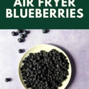 Dehydrated blueberries on a white plate with the words air fryer blueberries and the URL www.twocloveskitchen.com.
