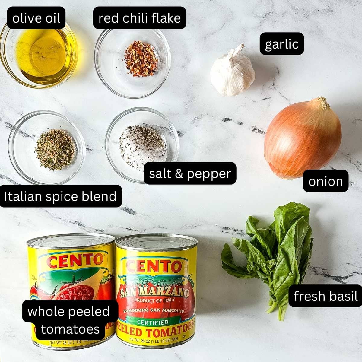 The labeled ingredients for hearty marinara sauce are shown on a white marble counter.