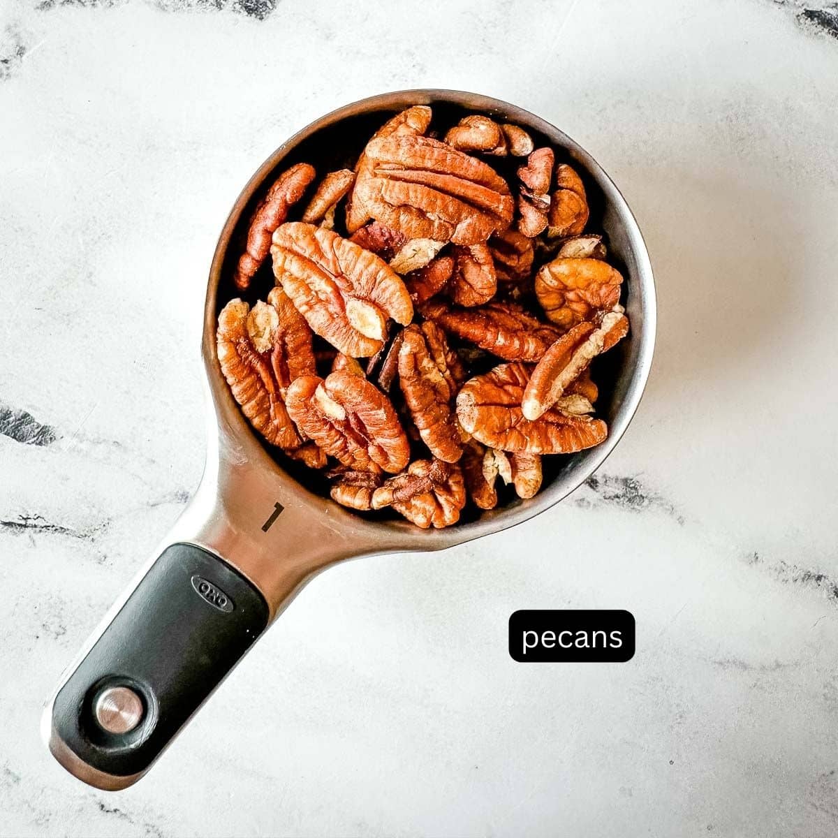 Labeled pecan halves in a measuring cup.