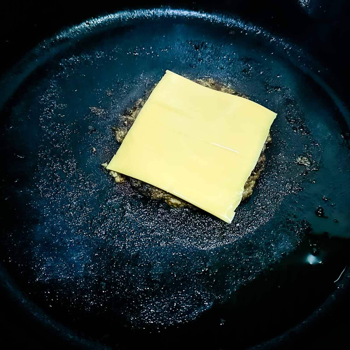 Cheese is melted on a turkey smash burger.