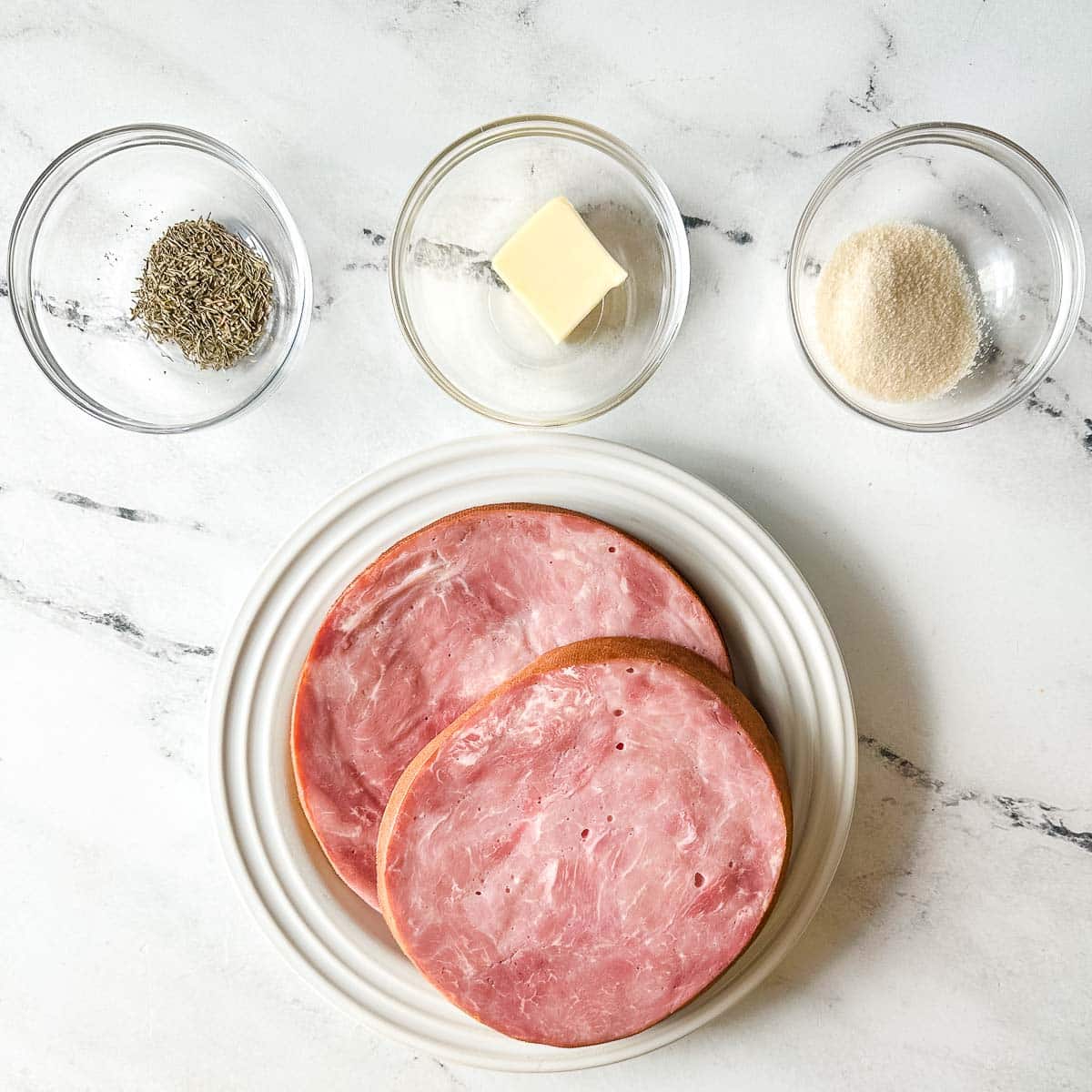 ingredients for air fryer ham steak on a white marble counter.