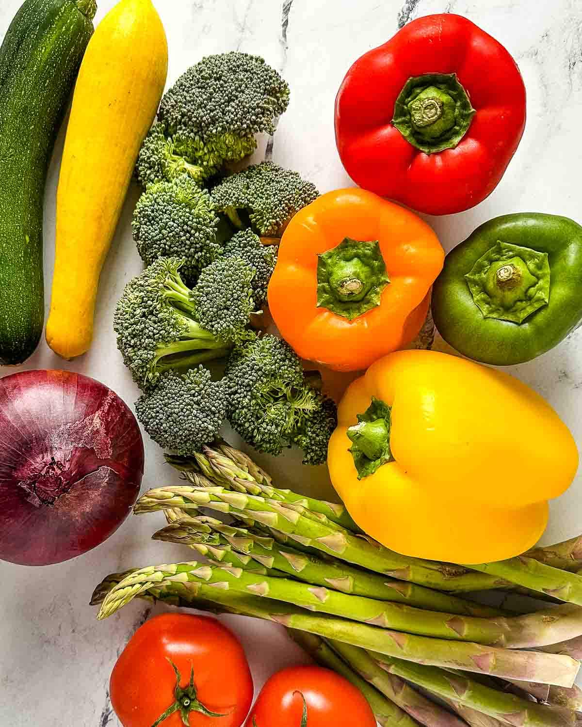 Fresh vegetables on a white marble counter.