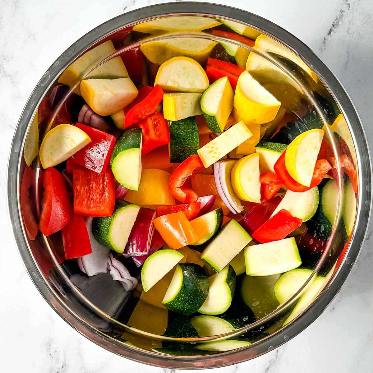 Cut vegetables in a stainless steel bowl.