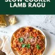 a white plate of slow cooker lamb ragu over pappardelle with the words slow cooker lamb ragu and the URL for two cloves kitchen dot com.