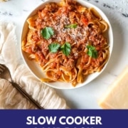 a white plate of slow cooker lamb ragu over pappardelle with the words slow cooker lamb ragu and the URL for two cloves kitchen dot com.