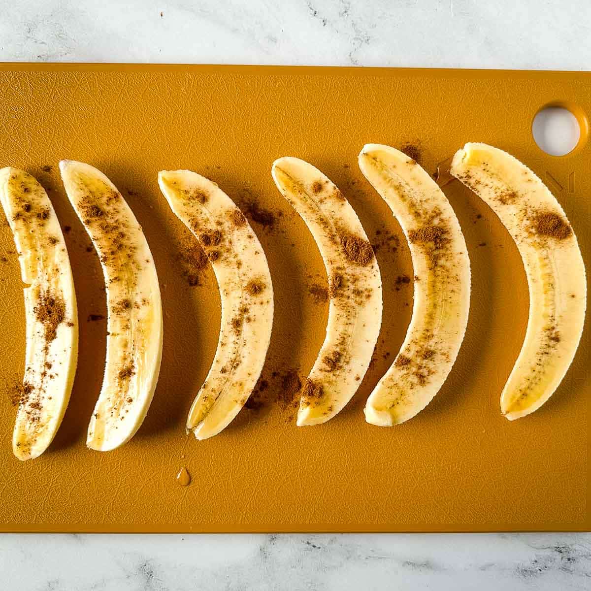 halved bananas are dusted with cinnamon.