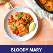 plate of bloody mary shrimp on peach tiles with the words bloody mary shrimp and the URL two cloves kitchen dot com.