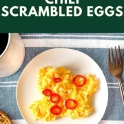 scrambled eggs topped with sliced chili pepper with the words Chili scrambled eggs and the URL two cloves kitchen dot com.