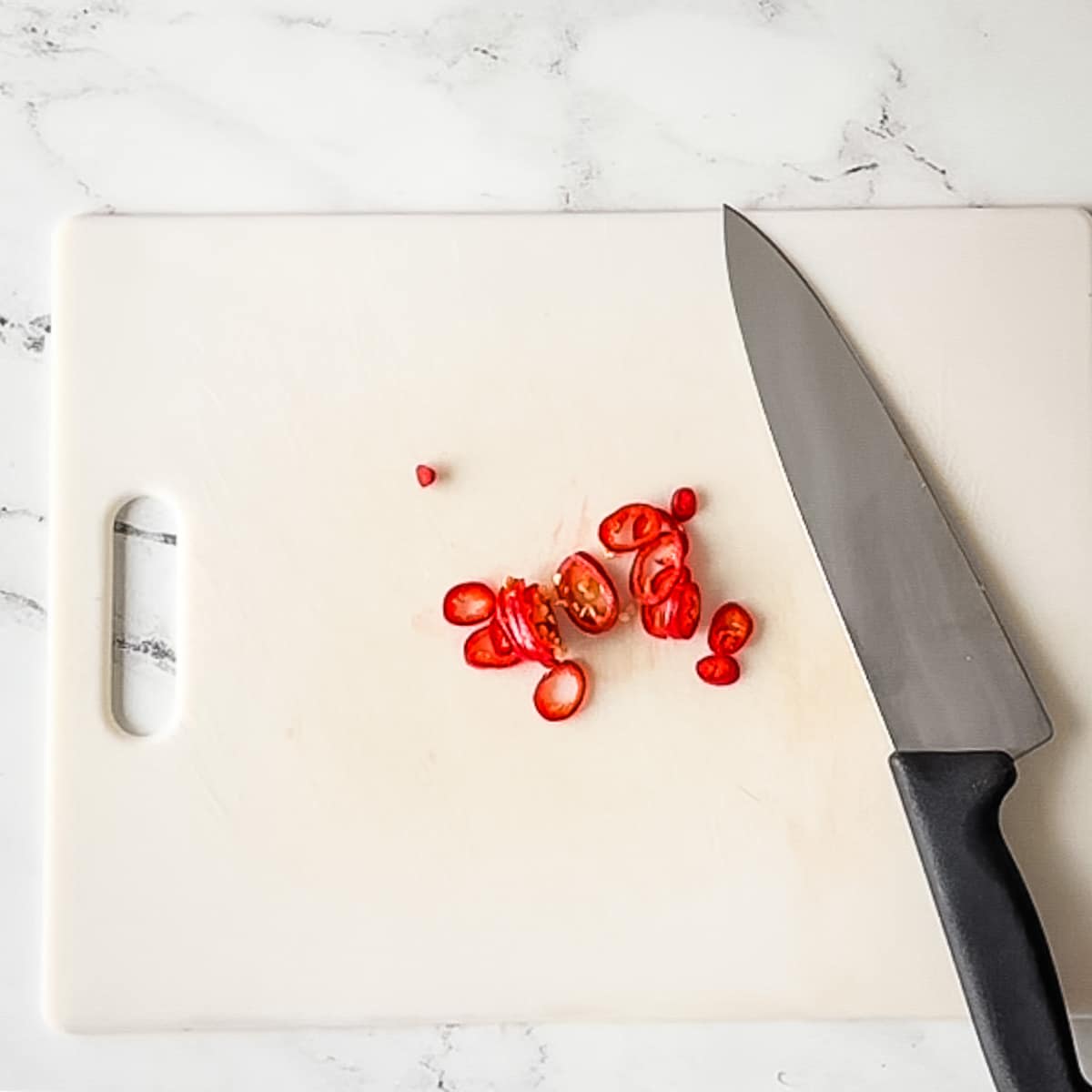 sliced fresno chili on a white cutting board.
