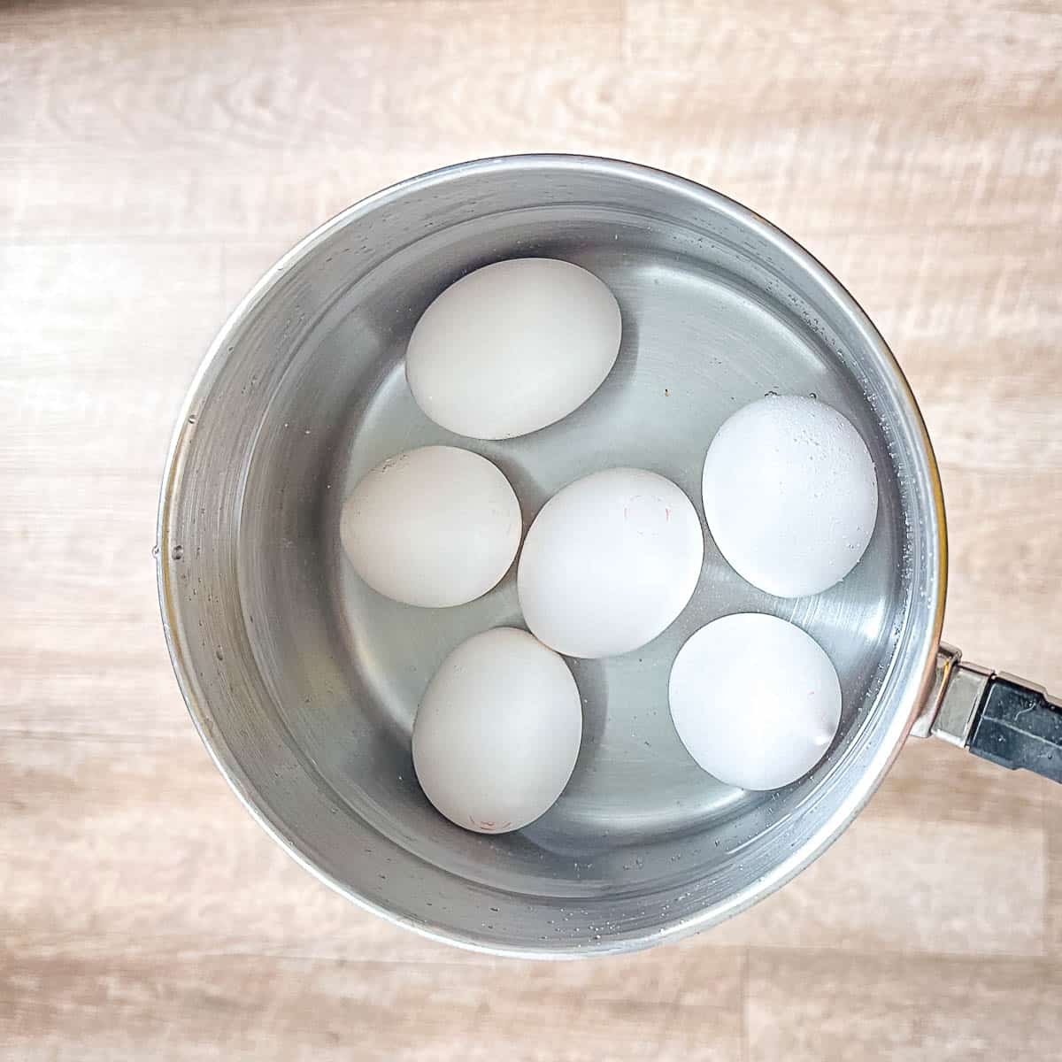 eggs covered with water in pot.
