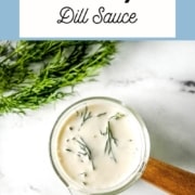 dill sauce in a small glass container with the words creamy dill sauce and the URL for two cloves kitchen dot com.