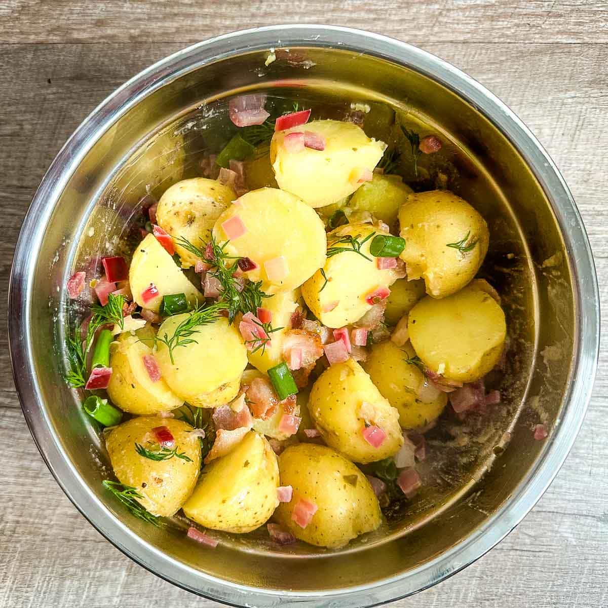 finished bavarian potato salad in a stainless steel bowl.