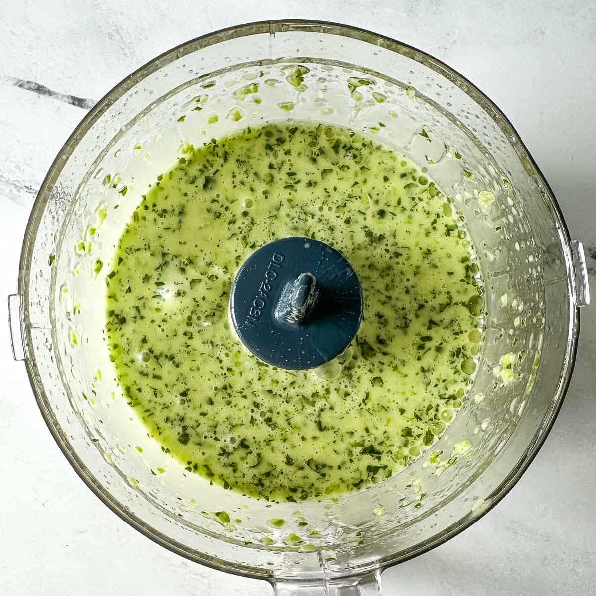 The blended vinaigrette is shown in a mini food processor.