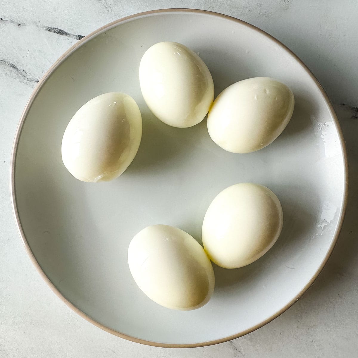 peeled hard-boiled eggs on a plate.