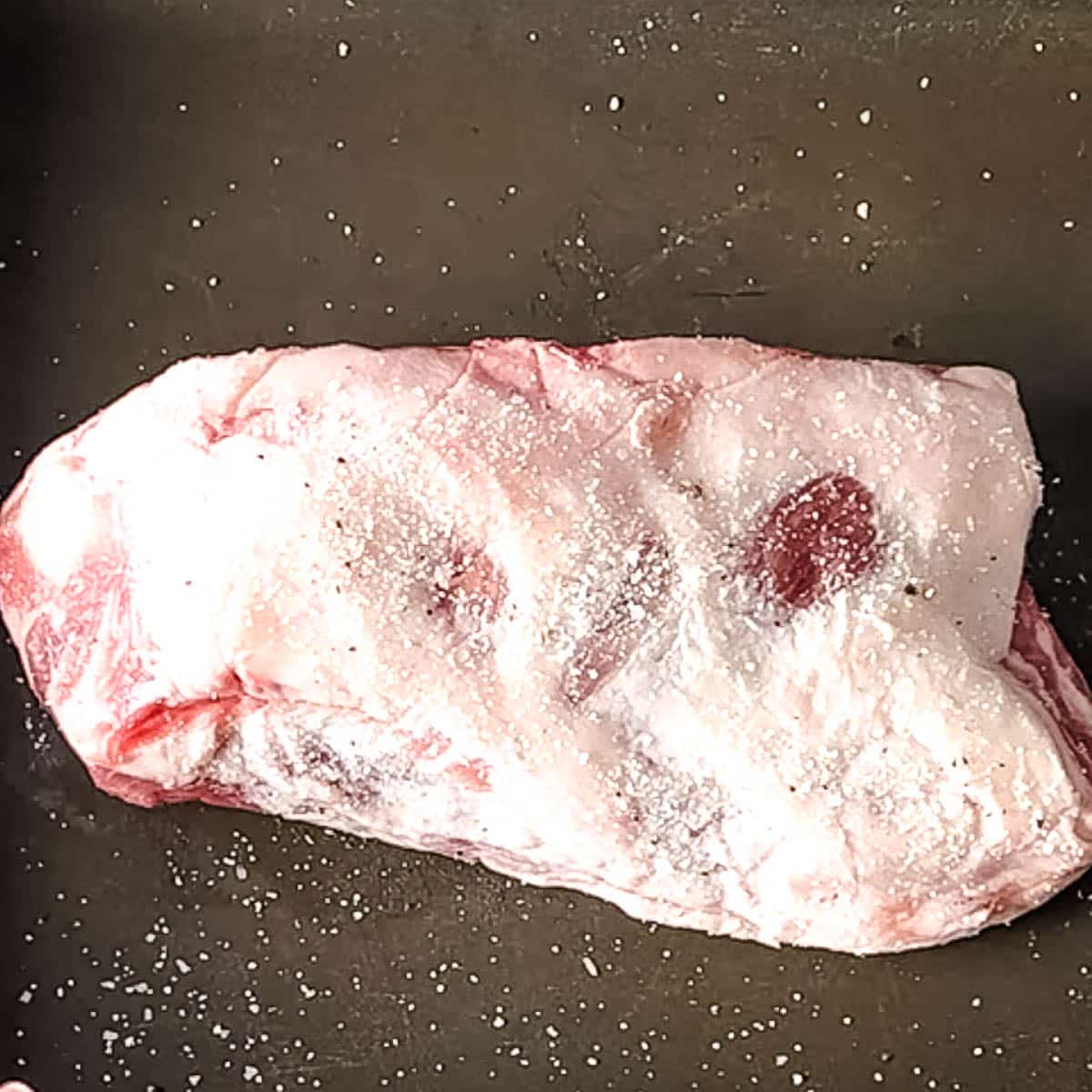 lamb breast seasoned with salt and pepper.