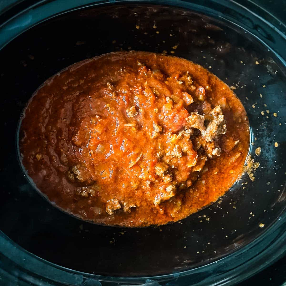 lamb ragu is transferred to a slow cooker.