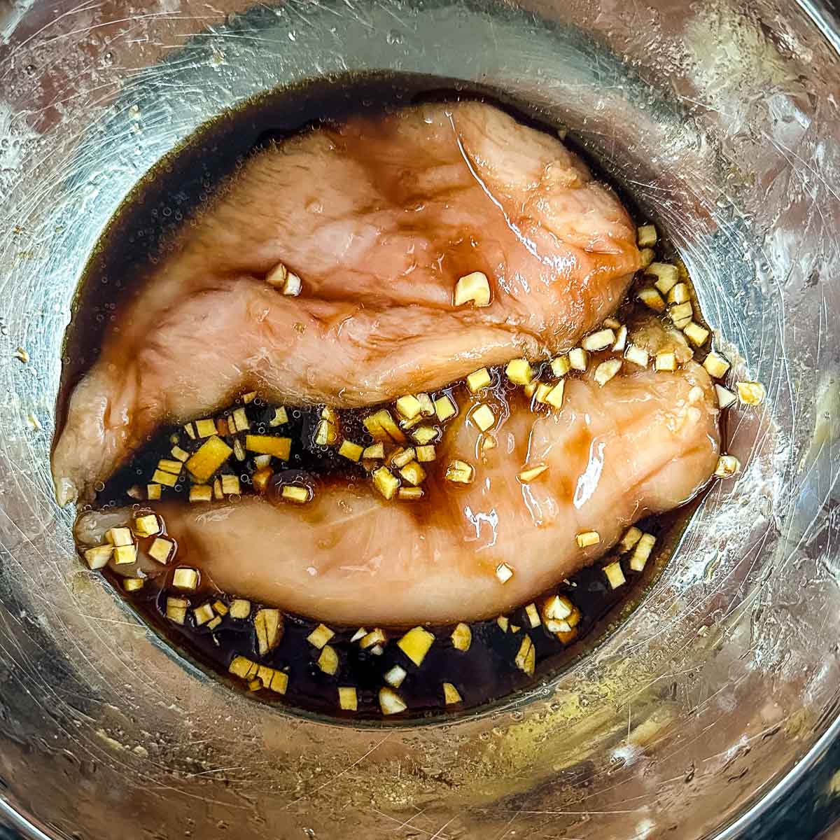 chicken marinating in soy sauce, garlic, and ginger.